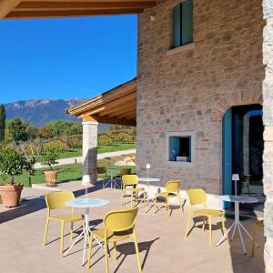 a patio with tables and chairs in front of a building at Agriturismo Riva Beata - Podere Cunial appartamenti, produzione e degustazioni vini Asolo Prosecco DOCG in Cavaso del Tomba