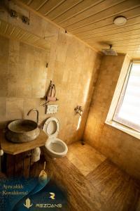 a bathroom with a toilet and a sink and a window at Panorama Rezidans Kayseri in Kayseri