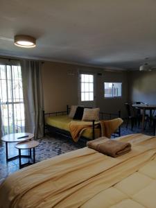 a bedroom with a large bed and tables and windows at Adonai, departamentos in El Bolsón