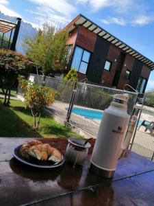 a table with a plate of bread and a bottle of water at Adonai, departamentos in El Bolsón