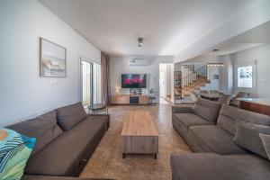 a living room with a couch and a table at Palm Villa Eva in Paralimni