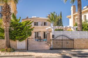 a white fence in front of a house at Palm Villa Eva in Paralimni