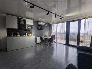 a kitchen and dining room with a table and chairs at TIRKIUS House in Kobuleti