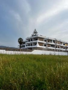 a large building on the beach with a grass field at Ivory Serenity in Theologos