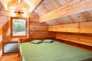 a bedroom in a log cabin with a bed at Dom nad Ińskiem in Scienne