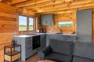 a kitchen with a couch in a tiny house at Dom nad Ińskiem in Scienne