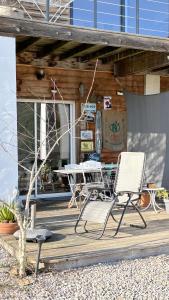 two chairs and a table on a wooden deck at Le studio de St Martin in Saint-Martin-de-lʼArçon