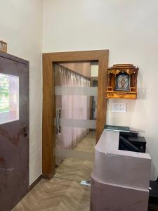 a room with a door and a clock on the wall at Bachelor Stay - CBD Belapur in Navi Mumbai
