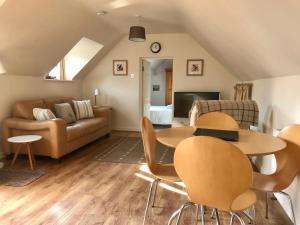 a living room with a couch and a table and chairs at The Hayloft, Wonderful Riverside Accommodation in Bodenham