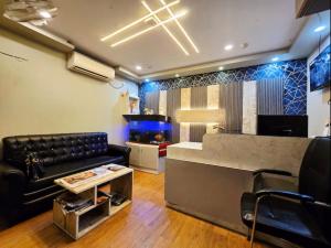 a living room with a couch and a fish tank at hotel Prime Plaza Newtown in kolkata