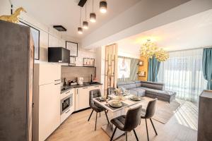 a kitchen and living room with a table and chairs at CosTan Apartment Infinity Spa & Parking in Mamaia Sat/Năvodari