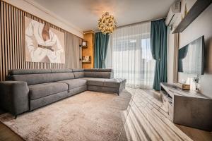a living room with a couch and a television at CosTan Apartment Infinity Spa & Parking in Mamaia Sat/Năvodari