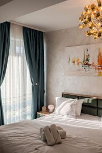 a bedroom with a bed with a chandelier at CosTan Apartment Infinity Spa & Parking in Mamaia Sat/Năvodari +52 photos