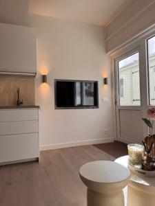 a white kitchen with a tv on the wall at Beach House Zandvoort in Zandvoort