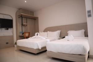 two beds in a hotel room with white sheets at Hotel Kantipur Plaza in Nepālganj