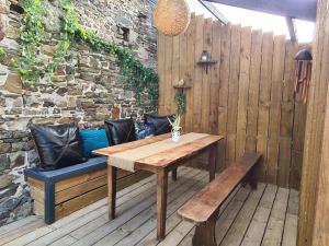 a wooden table and bench on a wooden deck at Le gîte "Hélaine" Charme, tranquillité, proche mer in Saint-Germain-sur-Ay