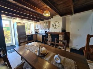 a kitchen and dining room with a wooden table at Le gîte "Hélaine" Charme, tranquillité, proche mer in Saint-Germain-sur-Ay