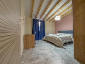 a bedroom with a bed and a blue curtain at ToNo House in Paterno