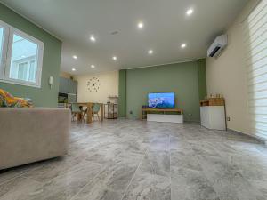 a living room with a couch and a tv on a wall at ToNo House in Paterno