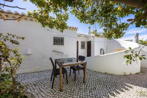 a table and chairs in front of a white house at Casa 54 in Valverde