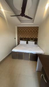 a bed in a room with a ceiling fan at jai shree hotel in Noida