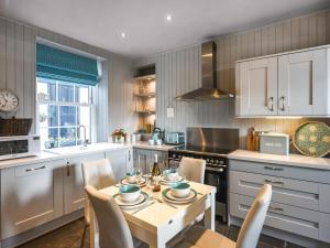 a kitchen with a table and chairs in a kitchen at Pandy Cottage in Aberdyfi