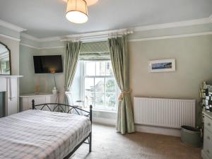 a bedroom with a bed and a window at Pandy Cottage in Aberdyfi