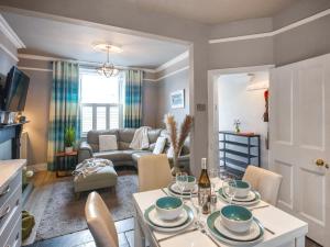 a kitchen and living room with a table and chairs at Pandy Cottage in Aberdyfi