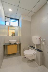 a bathroom with a toilet and a sink at hotel mon ville alkapuri in Vadodara