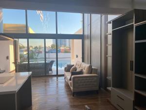 a living room with a couch and a large window at Loft One Bedroom with Shared Private Pool in Aglantzia +39 photos
