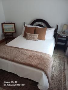 a bedroom with a large bed with white sheets and pillows at 21A On VDR in Oudtshoorn