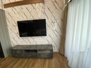 a living room with a television on a stone wall at Loft One Bedroom with Shared Private Pool in Aglantzia