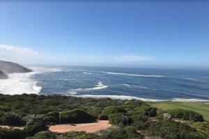an aerial view of the ocean and a golf course at Pinnacle Golf Estate Haven in Mossel Bay +65 photos