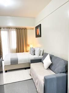 a hotel room with a bed and a couch at La Montañosa at Brenthill Baguio Condo near City Center in Baguio