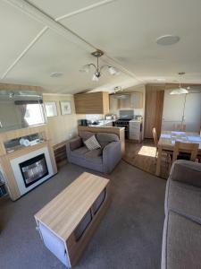 a living room with a couch and a table at Cleethorpes Beach Haven - Broadland Drive in Cleethorpes