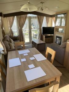 a living room with a table and a couch at Cleethorpes Beach Haven - Broadland Drive in Cleethorpes