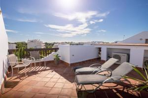 a patio with chairs and a fireplace on a balcony at Marina d'Or III - Villa 10 in Santanyi