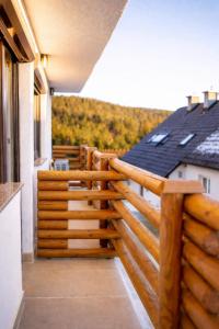 a balcony with a wooden fence on a house at Apartmaji Ježek Kope in Šmartno pri Slovenj Gradcu