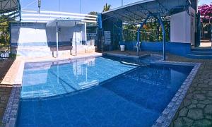 a swimming pool with blue water in a house at Hotel Tagudan Kubo Corporation in Tagudin