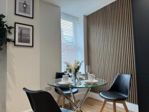 a dining room with a glass table and chairs at Stylish 2 Bedroom Coastal Apartment near Crosby Beach & Liverpool in Waterloo
