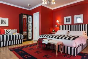 two beds in a room with red walls at Areela Boutique Hotel in Tirana
