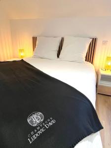 a bed with a black sign on top of it at La Maisonnette Champenoise in Villers-sous-Châtillon