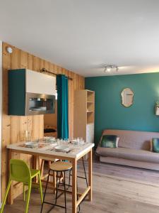 a living room with a table and chairs and a couch at Gites du Rioul in Les Estables
