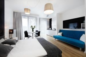 a bedroom with a large bed and a blue couch at Kalia Apartments in Warsaw