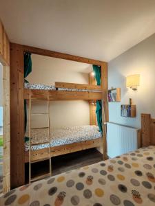 two bunk beds in a room with a bed at Gites du Rioul in Les Estables