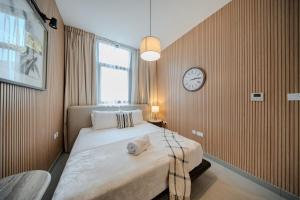 a bedroom with a bed with a clock on the wall at The Clay Loft Stylish 1BR with Pool Parking CB2-1-RA2-707-1br in Sharjah