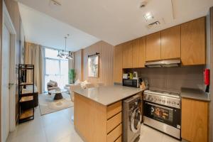 a kitchen with wooden cabinets and a stove top oven at The Clay Loft Stylish 1BR with Pool Parking CB2-1-RA2-707-1br in Sharjah +33 photos