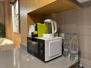 a kitchen counter with a blender on top of a microwave at The Clay Loft Stylish 1BR with Pool Parking CB2-1-RA2-707-1br in Sharjah