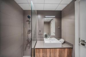 a bathroom with a sink and a shower at The Clay Loft Stylish 1BR with Pool Parking CB2-1-RA2-707-1br in Sharjah