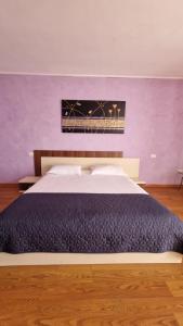 a bedroom with a large bed with a purple wall at Casa Ioanele in Valea Perilor +2 photos